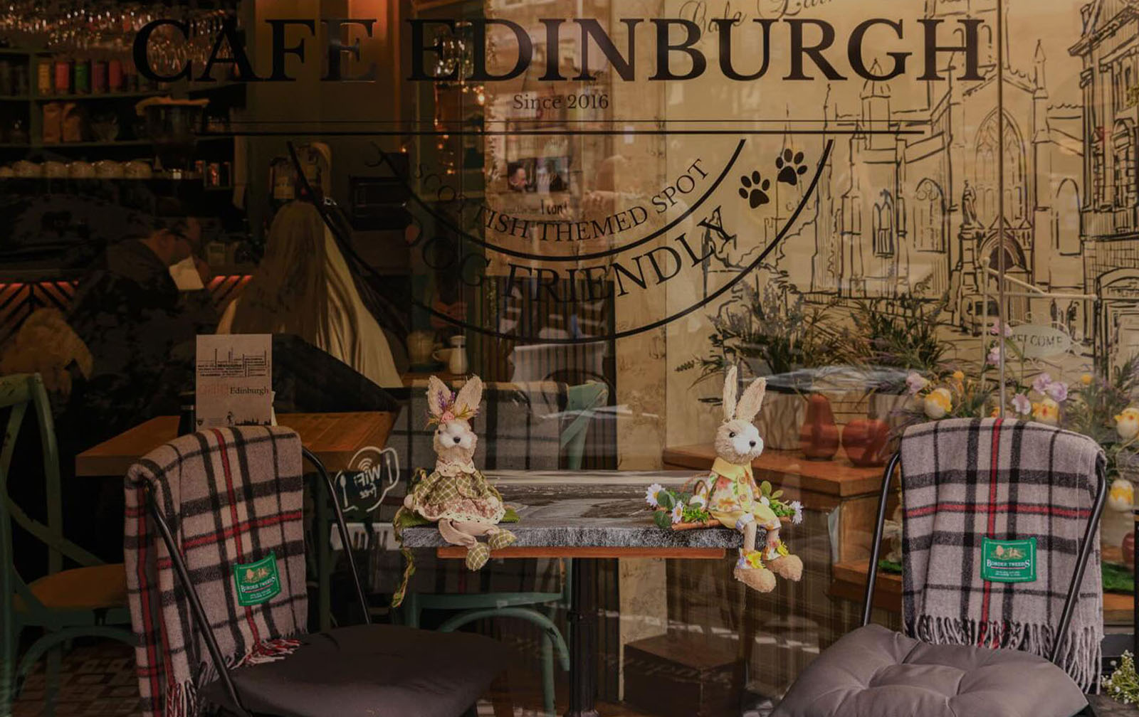 Dark candlelit interior of Cafe Edinburgh with walnut floors and leather banquettes